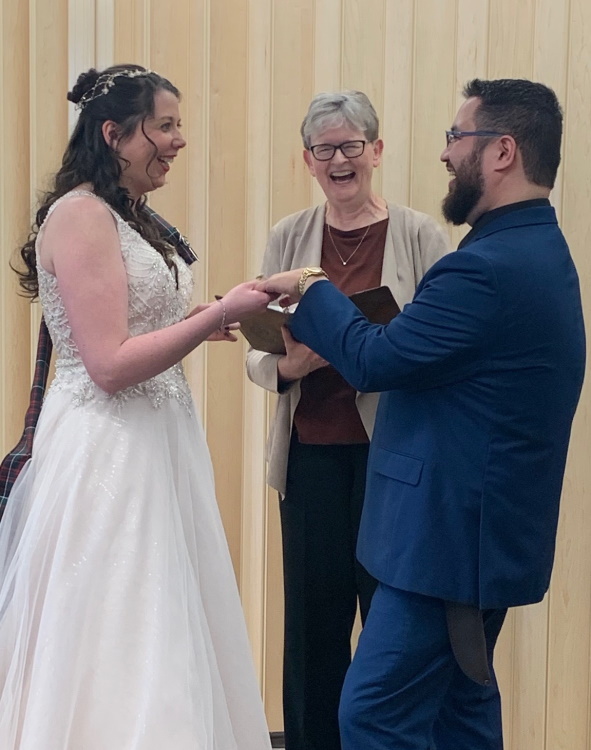 Wedding couple with female reverend in the middle